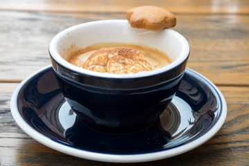 A cup of delicious morning affogato coffee with a ball of tasty vanilla ice cream and homemade ginger cookie