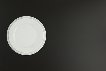 ceramic kitchen plate on black background, top view