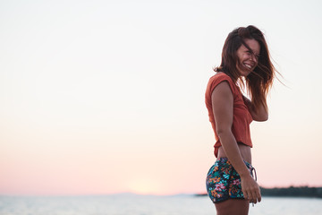 Young woman enjoying sunset by the sea