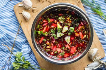 Cold soup Chrianteli with sour cherry or blackberry juice. Georgian traditional summer food with garlic, green herbs, cucumbers. Raw vegan vegetarian healthy food.