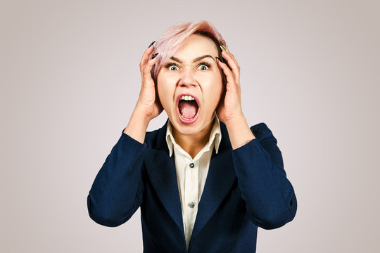 Young girl office worker screams for fear, isolated on a pink background