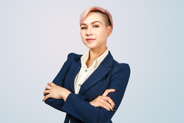 Portrait of young business woman with crossed arms, isolated on a blue background