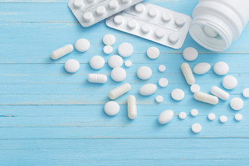 white pills on  blue wooden background