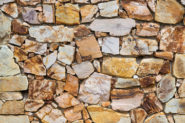 Decorative stone wall, pieces of rock bonded with cement. Cobble texture with cracks. Mountain of castle San Juan. Spanish beach resort Blanes in summertime, Costa Brava, Catalonia, Spain