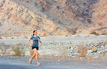 Female running in the desert road