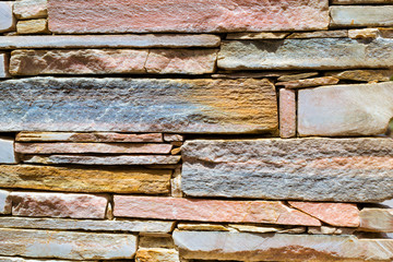 Decorative stone wall, pieces of rock bonded with cement. Cobble texture with cracks. Mountain of...