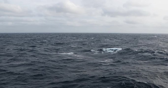 Clip of forboading waves under a cloudy sky.