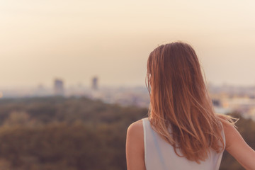 Single woman looking at the distant city landscape.