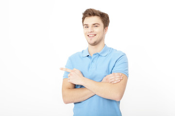 Young guy pointing copy space isolated on white background. Handsome young smiling man in shirt looking at camera and pointing away. Student. Copy space. Mock up