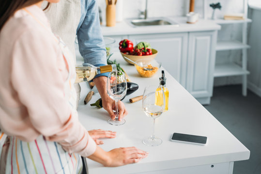 cropped image of boyfriend pouring wine into glass