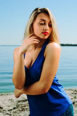 Fototapeta na wymiar the athlete on the beach posing. blonde girl with big eyes posing