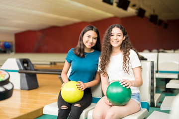 Smiling Friends With Bowling Balls In Club