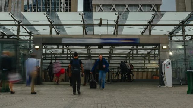Time lapse of people walking and entering the metro station close to modern buildings in Paris business district. Glass facade skyscapers. Urban life, transportation, business, job and economy concept