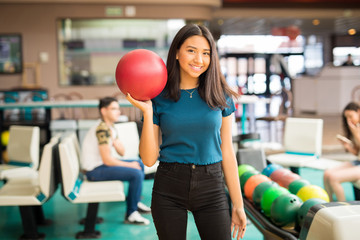 Teenage Girl Carrying Red Bowling Ball In Club