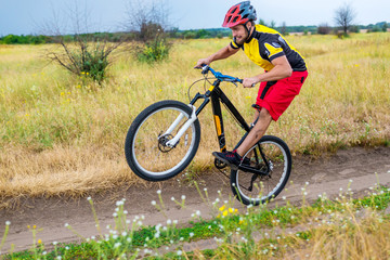 Obraz premium Cyclist riding on the rear wheel of the bicycle, active lifestyle.