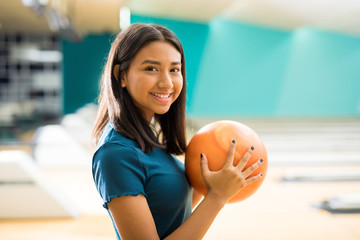 Girl With Ball Having Fun At Bowling Alley In Club