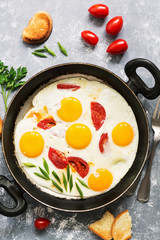 Fried eggs with tomatoes in a pan. Breakfast, flat lay.