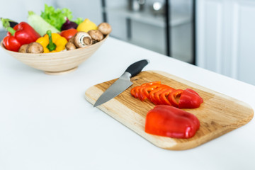 close-up view of sliced bell pepper and knife on wooden cutting board
