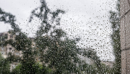 Drops of rain on the window glass on a blurred background. Selective focus.
