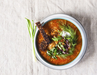 Traditional Ukrainian Russian borscht with white beans on the bowl. Plate of red beet root soup borsch on black rustick table. Beetroot soup Top view. Traditional Ukraine food cuisine