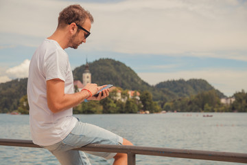 Modern man using cellphone outdoors.