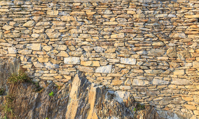Trockenmauer aus Naturstein mit Bewuchs