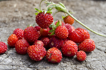 Ripe forest strawberries on rough wooden surface