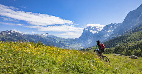 nice and ever young senior woman riding her e-mountainbike in Jungfrauregion,Switzerland, alps