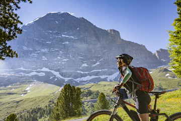 nice and ever young senior woman riding her e-mountainbike below the Eiger Northface near...