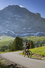 nice and ever young senior woman riding her e-mountainbike below the Eiger Northface near Grindelwald and Wengen, Jungfrauregion, Switzerland