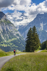Fototapeta na wymiar nice and ever young senior woman riding her e-mountainbike below the Eiger Northface near Grindelwald and Wengen, Jungfrauregion, Switzerland