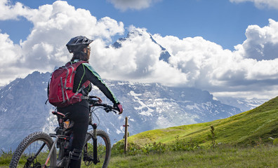 nice and ever young senior woman riding her e-mountainbike below the Eiger Northface near...