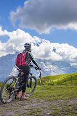 nice and ever young senior woman riding her e-mountainbike below the Eiger Northface near Grindelwald and Wengen, Jungfrauregion, Switzerland