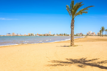 European sandy beach, boat and blue sea.