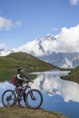 Fototapeta premium nice and ever young senior woman riding her e-mountainbike below the Eiger northface, Jungfrauregion, Switzerland