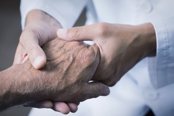 man moving the hand of a senior patient