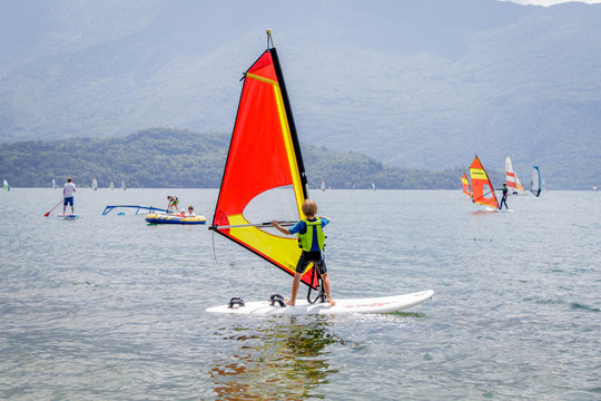 Little boy is learning how to windsurf in Domaso at Lake Como, Italy.