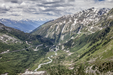 Fototapeta na wymiar Furka Pass and Grimsel Pass in the swiss alps in early summer with still snow on the mountains