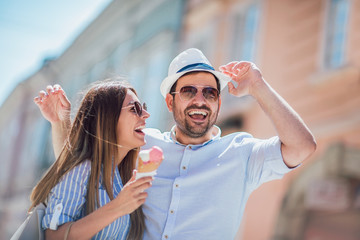 Happy couple having date and eating ice cream after shopping
