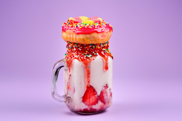 Freakshake. Extreme milkshake with strawberry, jelly sweets, donut.