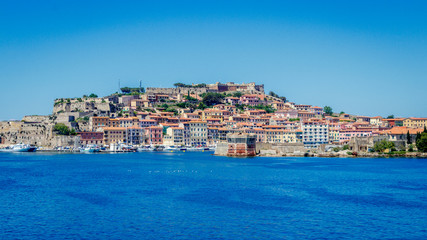 Fototapeta na wymiar The town of Portoferraio seen from the Ferry coming from Piombino. Portoferraio is a town and comune in the province of Livorno, on the edge of the eponymous harbour of the island of Elba. 