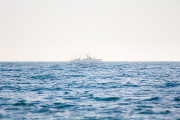 A warship on the horizon of the sea