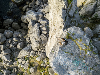 lonely man sitting on the mountain cliff and thinking about life