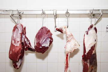 WORK PLACE OF BUTCHER. BEEF AND PORK HANGING ON HOOK