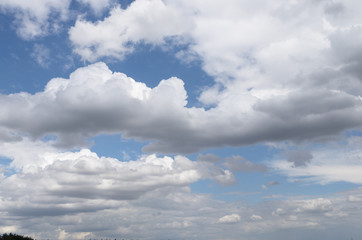 Blue sky with white and gray rain clouds on summer day; Overcast, receding to the horizon