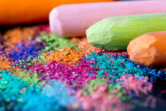 Crumbs of multi-colored chalk on a black background. Joy, Carnival, Panorama. A game for children. Art