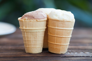 Vanilla ice cream in waffle cup isolated on wooden background. Summer concept.
