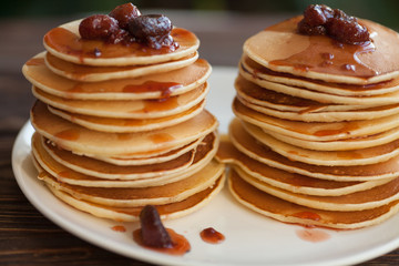delicious pancakes on wooden table with strawberry jam