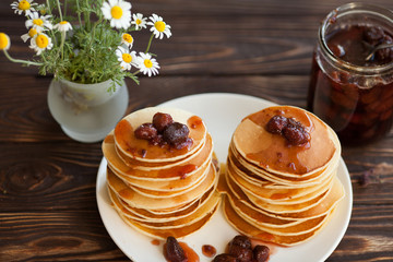 Delicious pancakes on wooden table with strawberry jam