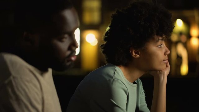 Sad couple sitting outside party club, inability to discuss problems, offend